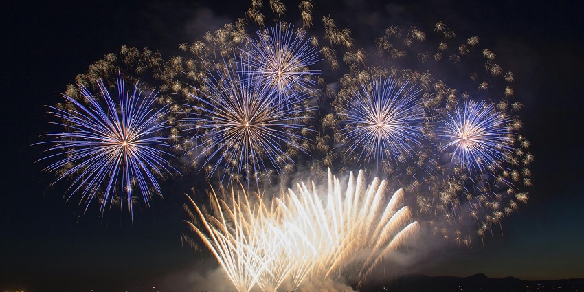 A vibrant fireworks display lights up the night sky over Cannes during a summer festival celebration.