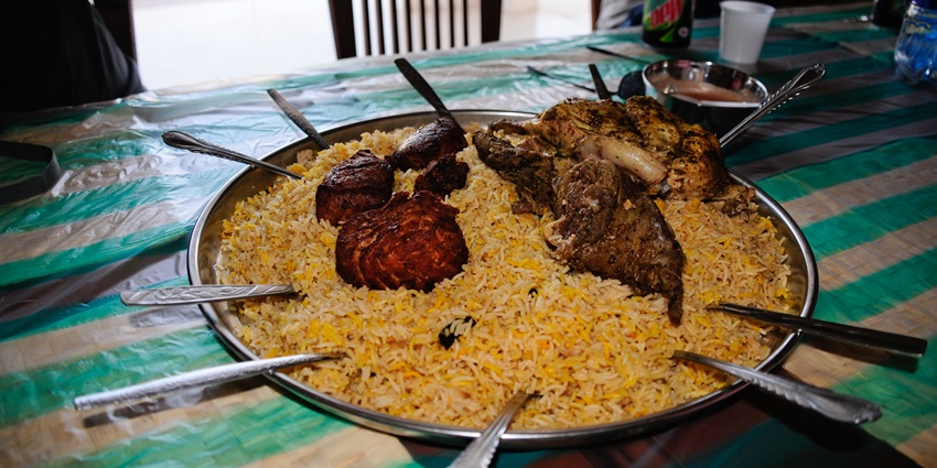 View of traditional Omani food showing biryani topped with chicken, a mouth - watering sight.

