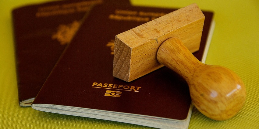 Traveler reviewing documents and passport before international departure at the airport.