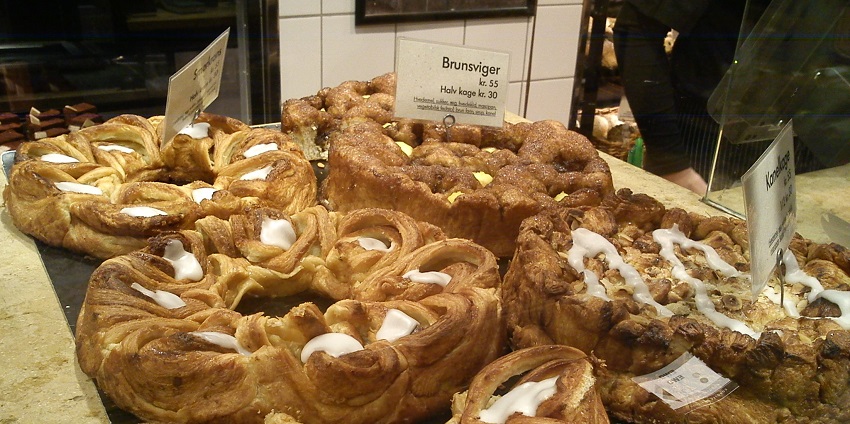 An image of flaky Danish wienerbrød pastry, which is filled with custard, jam and icing.
