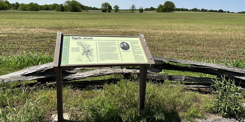 Wilson’s Creek National Battlefield with green grass plains, trees, one of the historical places in Missouri.