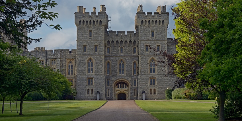 Entrance to Windsor Castle with a road leading to the entrance and traditional architecture