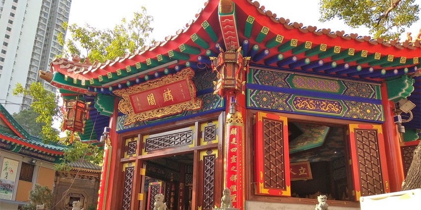 Colourful Taoist temple with traditional Chinese roofs and lanterns, one of the historical places in Hong Kong.