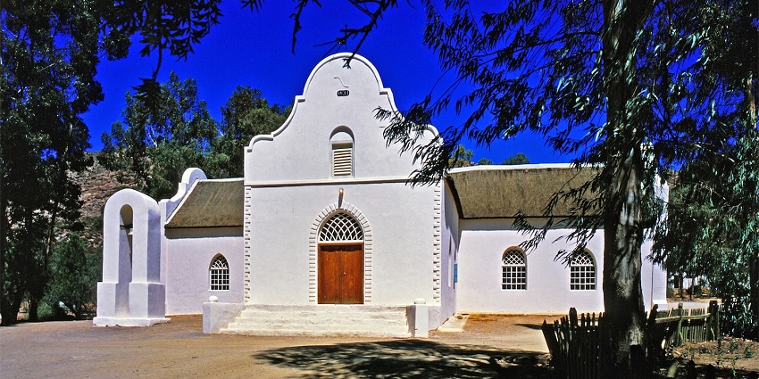 Church in Wuppertal mission village with white architecture, a small brown gate and windows, one of the best hidden places in South Africa
