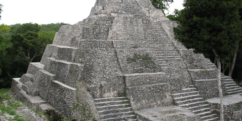 Stone structures and lakeside setting at Yaxhá ruins in Guatemala