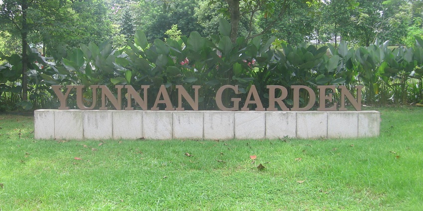 The entrance of the grand Yunnan Garden in Singapore with its lush greenery during daylight.