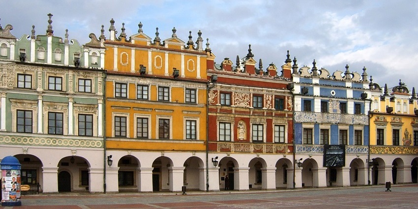 Zamość Old Town with multiple vibrant coloured buildings and street lamps on the buildings