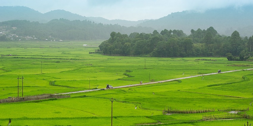 Hills in Arunachal Pradesh with dense green trees and sun rays from behind the hills