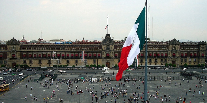 A large Mexican flag waves in the centre of the historic Zócalo plaza, in Mexico