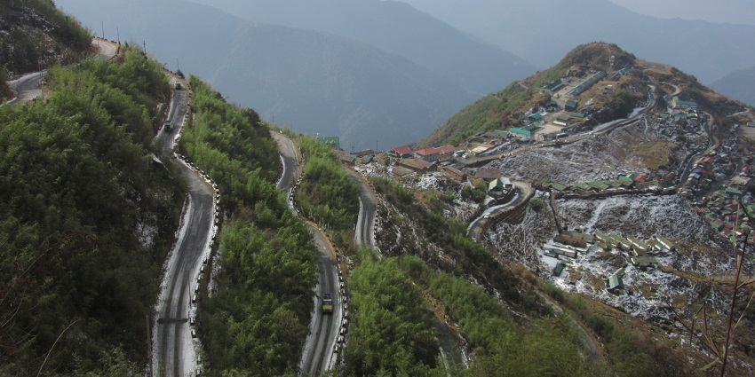 Twisting winding roads up a high-altitude landscape shrouded in autumn haze, one of the best places to visit in Sikkim in October.