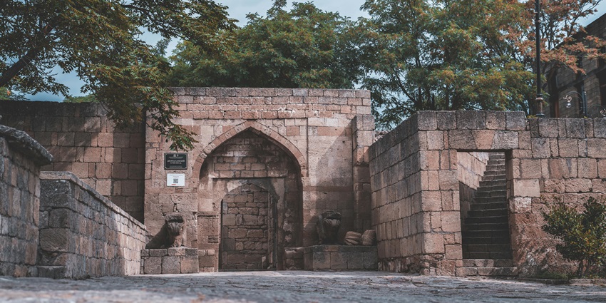 Main entrance gate of Derbent fortress with stairs leading to the gate and unique lamps