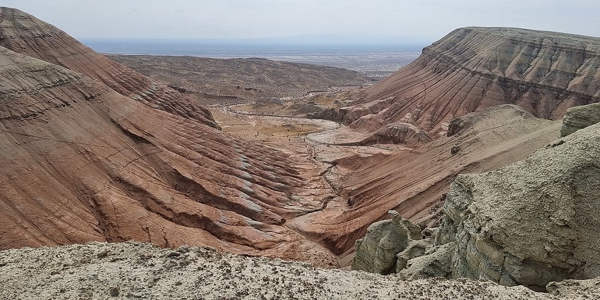 Rugged brown hills of Altyn Emel stretch across a dry, rocky landscape under an open sky.