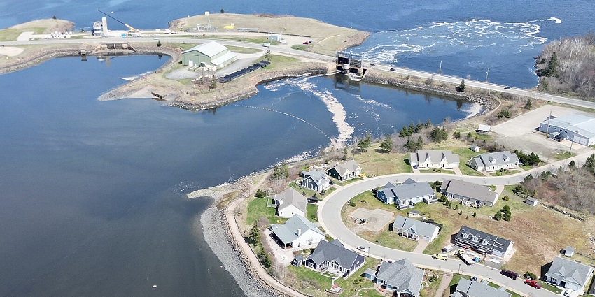 Aerial view of Annapolis Royal with buildings, winding roads, and calm waterfront.