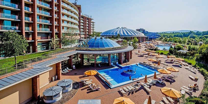 Modern resort complex with outdoor pools, sun loungers, and a large dome-shaped spa, amongst the top places to visit near Budapest.