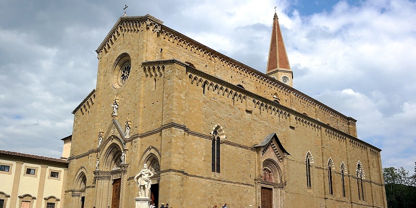 Gothic-style cathedral with a tall spire, rose window, and a staircase lined, amongst the best places to visit near Florence.
