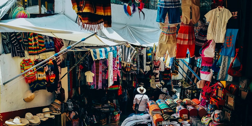People browsing stalls with clothes, food, and crafts at Arpora Saturday Night Market.