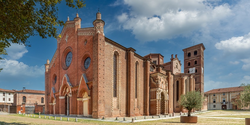 Entrance of the Cathedral of Santa Maria with traditional Christian architecture and small trees.