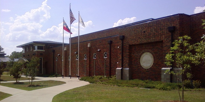 Pearl Community Centre with multiple tall flags on the front and a red architectural building.