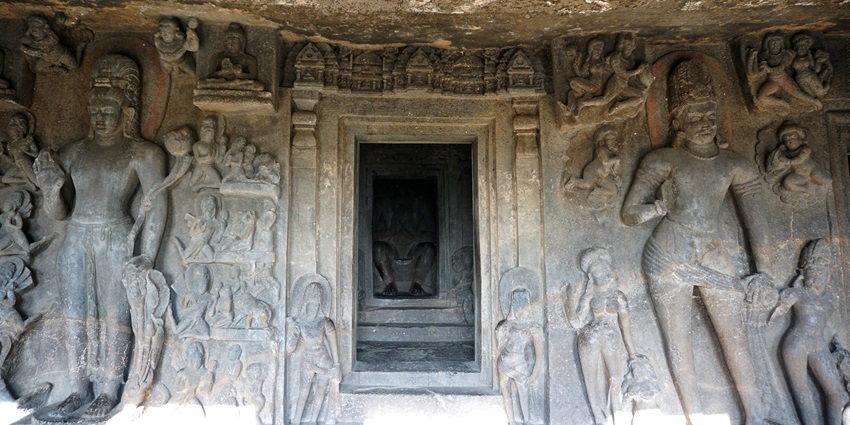 The interior of the Aurangabad Caves features carved stone arches and Buddhist sculptures.