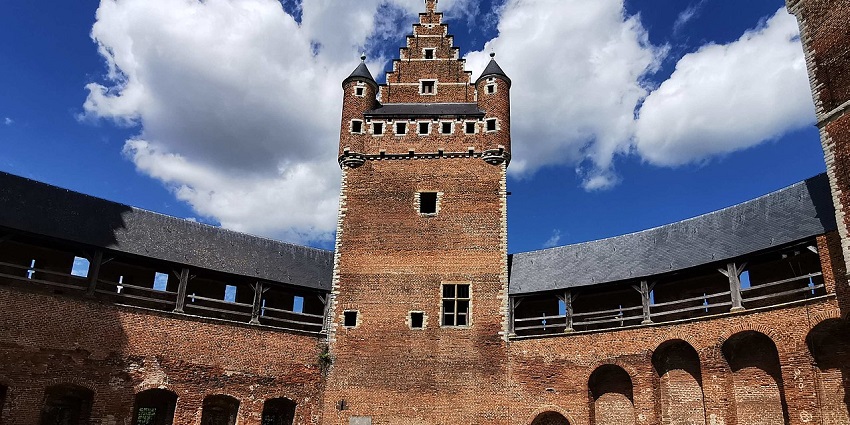 Medieval brick castle courtyard with stepped gables, arched walkways, and towers amongst the best places to visit near Brussels.
