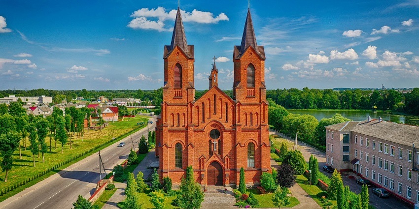 Statue of the Virgin Mary in Miory, Belarus surrounded by greenery and sky.
