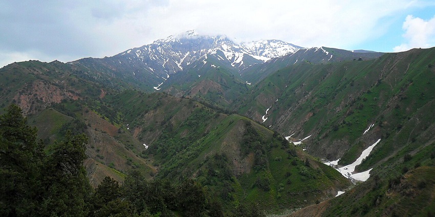 Beldersay Valley in spring with green hills and snowy peaks, scenic places to visit near Tashkent.