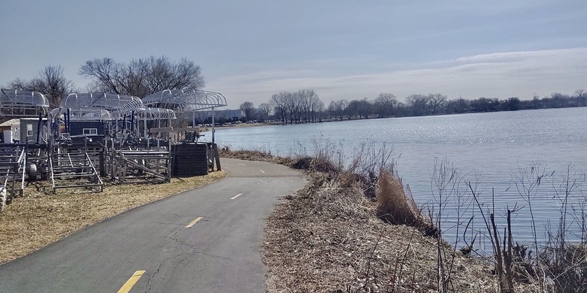 Medicine Lake regional trail with a large water body of the lake on the side and a walking pathway, one of the best things to do in Plymouth MN.