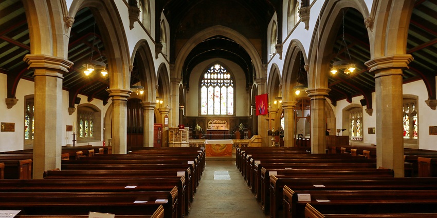 Interior of St. Michael and All Angels Church in Blantyre, featuring arched ceilings and pews.