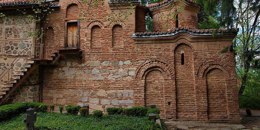 Exterior view of Boyana Church in Sofia with old stone walls and tiled roof.