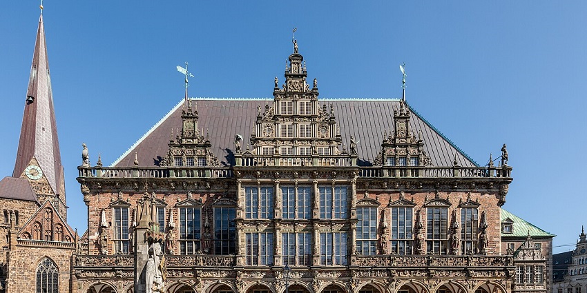 Historic town square with ornate Renaissance-style building, statue, one of the best places to visit near Hamburg.