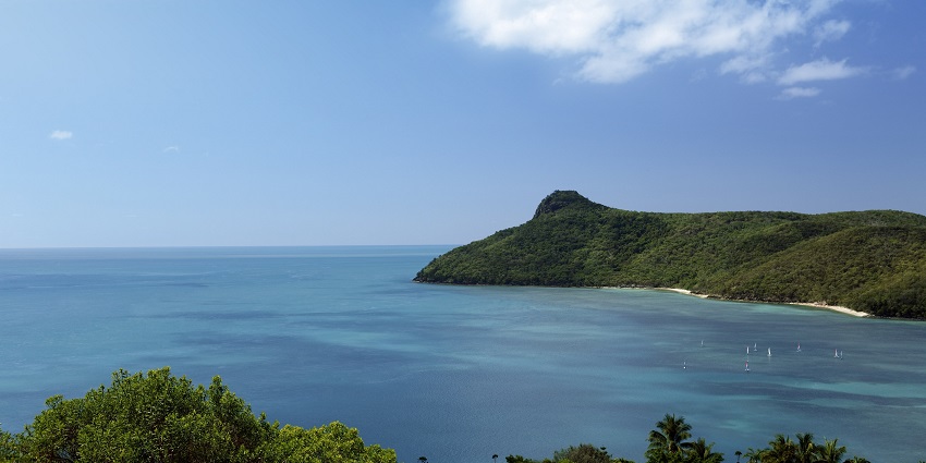 The passage peaks at Hamilton Island with a dense green mountain and distant sailing boats.