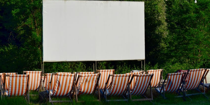 Open-air cinema theatre with a white screen, multiple red and white striped seats, one of the best things to see in Oregon Ohio.