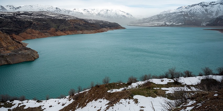 Charvak Reservoir with turquoise water and snowy mountains, top places to visit near Tashkent.