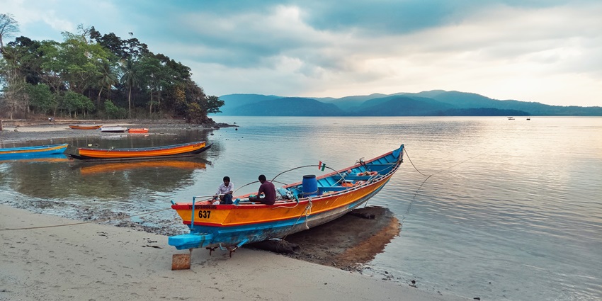 An image of the Chidiya tapu in Andaman with two boats resting on the shore of the sea
