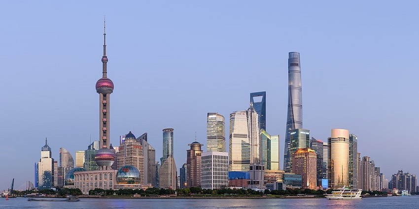 Panoramic view of Shanghai’s Pudong skyline with skyscrapers and a river in front, one of the best places to visit near Thailand.
