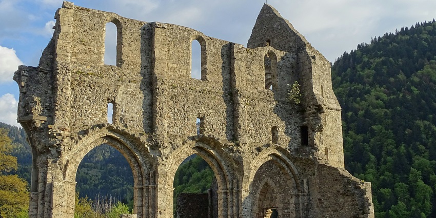Ancient monastery ruins surrounded by greenery in the medieval town of Crémieu.