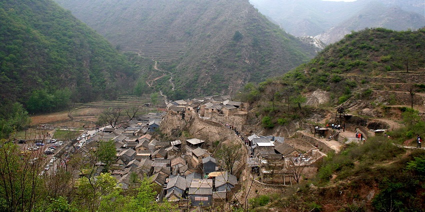 Cuandixia Village with traditional courtyard homes and narrow lanes along a green hillside.

