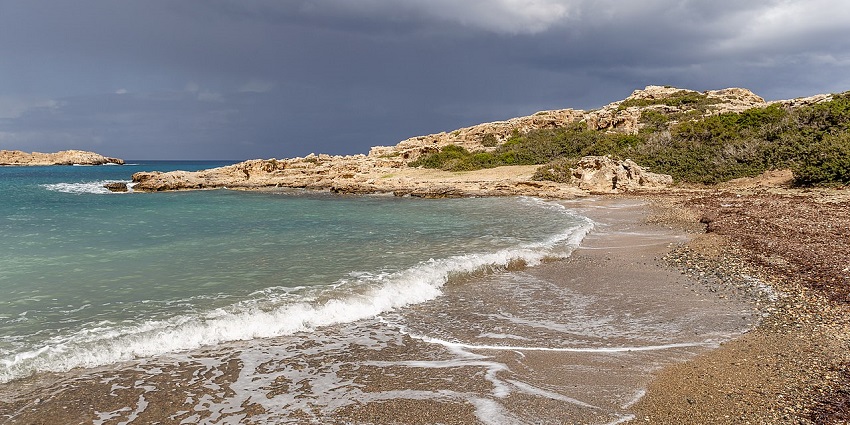 Amphitheatre Bay in Cyprus, with turquoise waters and rugged cliffs, among the top places to visit near Turkey.
