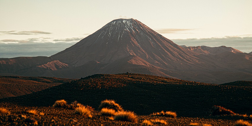 Lava-filled crater of Mount Nyiragongo surrounded by rugged terrain places to visit near Kenya.