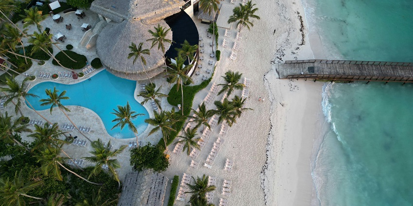 The scenic beauty of Dominicus Beach from above, with golden sands and vibrant blue ocean waves.