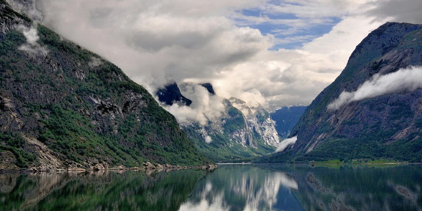 Numedalslågen River with clear blue water flowing through a green, forested landscape.