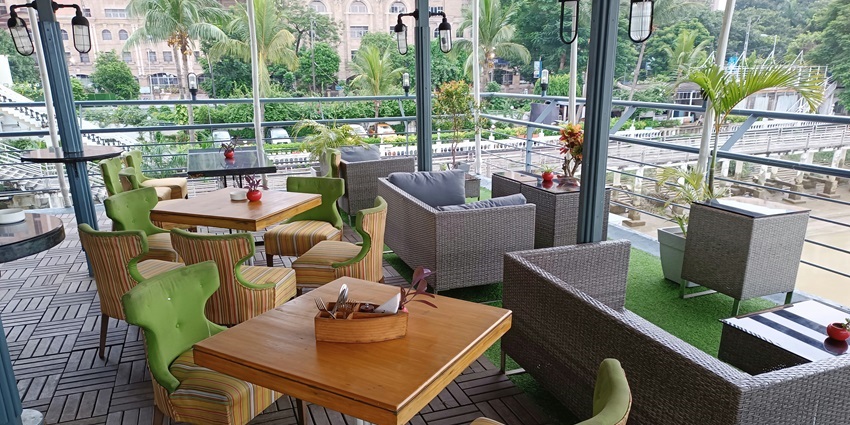 Rooftop restaurant with tables and chairs, and large windows overlooking the city.