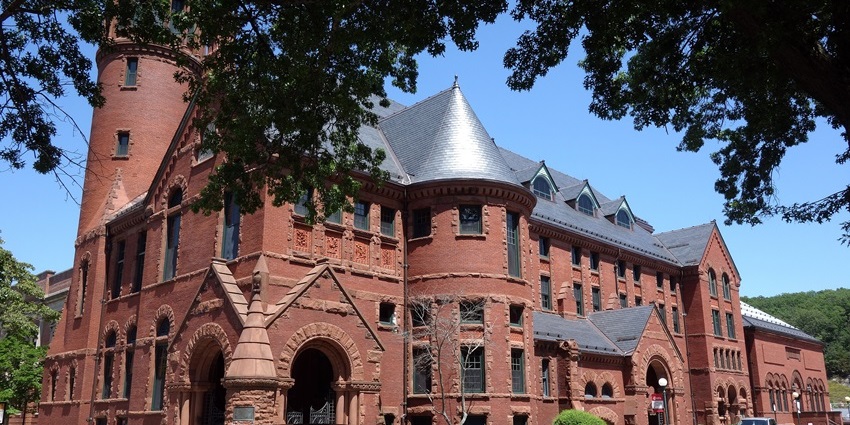 Historic red-brick building with arched entrances, turrets, and detailed stonework, one of the best things to do in Norwich CT.