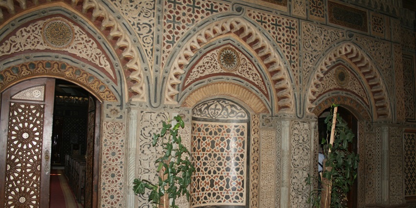 Interior of the Hanging Church in Cairo, showcasing Coptic icons, arches, and calligraphy.