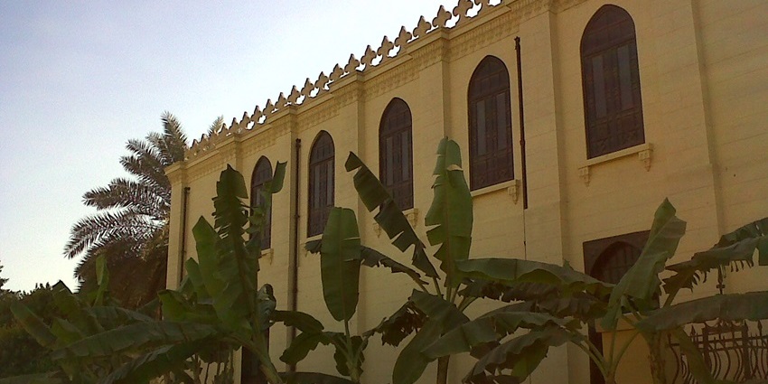 Banana trees in front of an old cream-colored building with arched windows, one of the best things to see in Old Cairo.