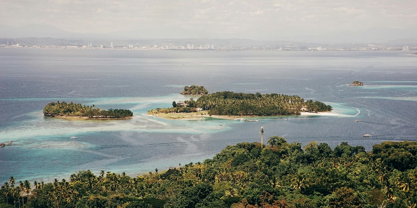 The lush green island of Utila Cay, surrounded by clear blue water, is one of the top things to do in Utila.