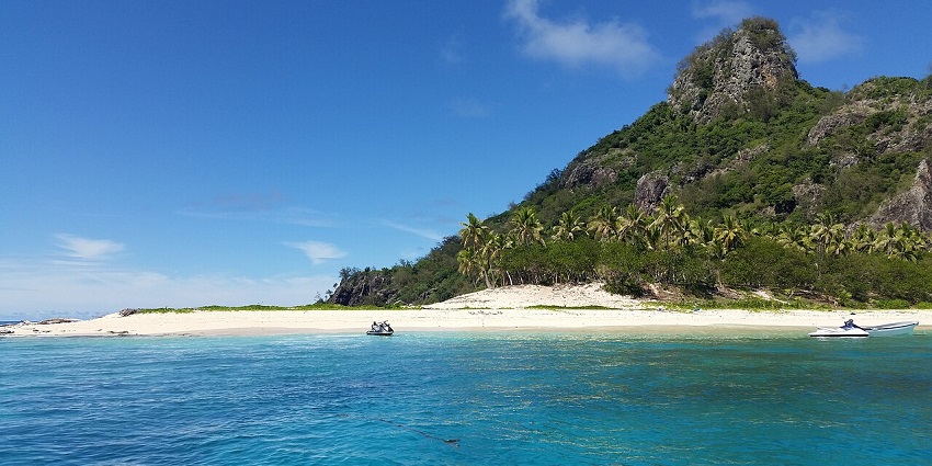 Monuriki Island with boats on the shore, among stunning places to visit near Australia.