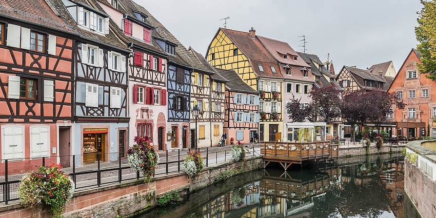 Charming canal in Little Venice, France, with colourful timbered houses and calm waters.
