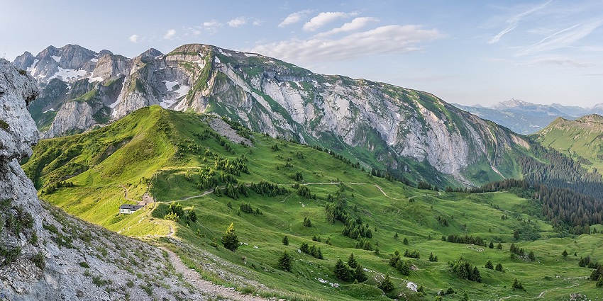 Striking folded rock layers at Rouleau de Bostan above grassy alpine terrain, stunning places to visit near Switzerland.