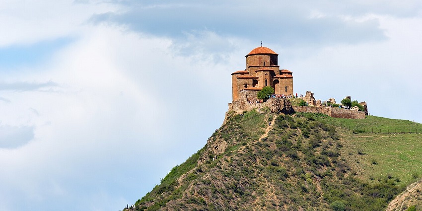 Jvari Monastery on a rocky hilltop with mountain views, amongst the historic places to visit near Qatar.